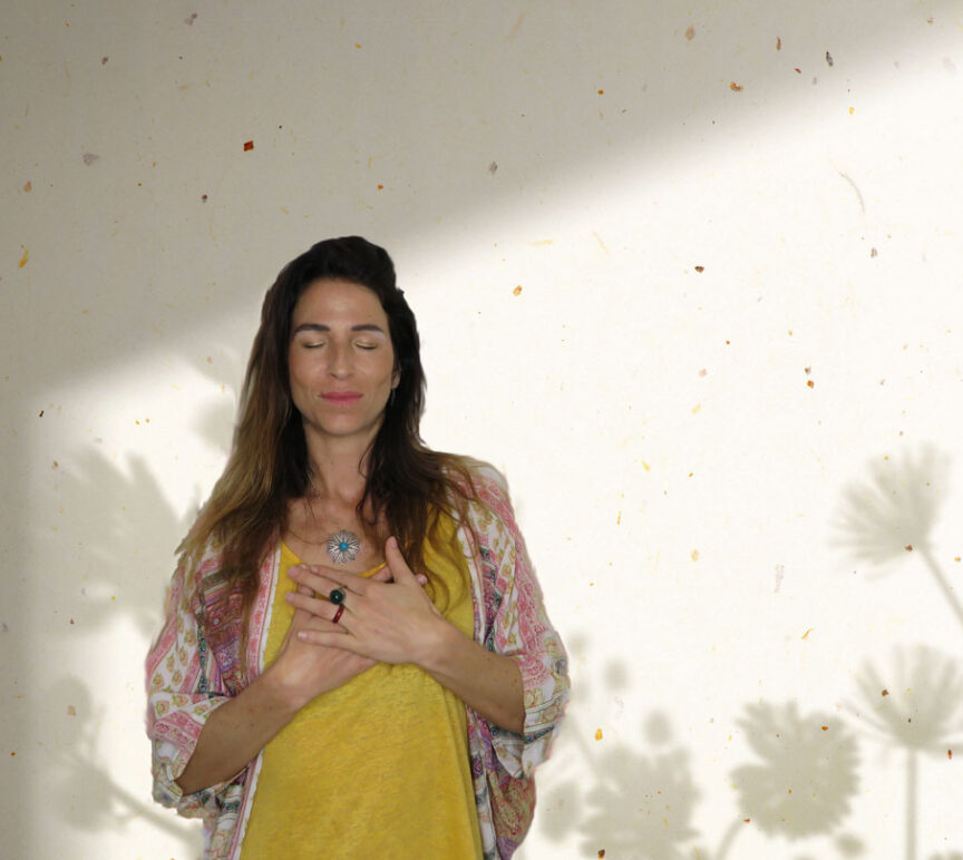 woman hugging herself standing against a wall